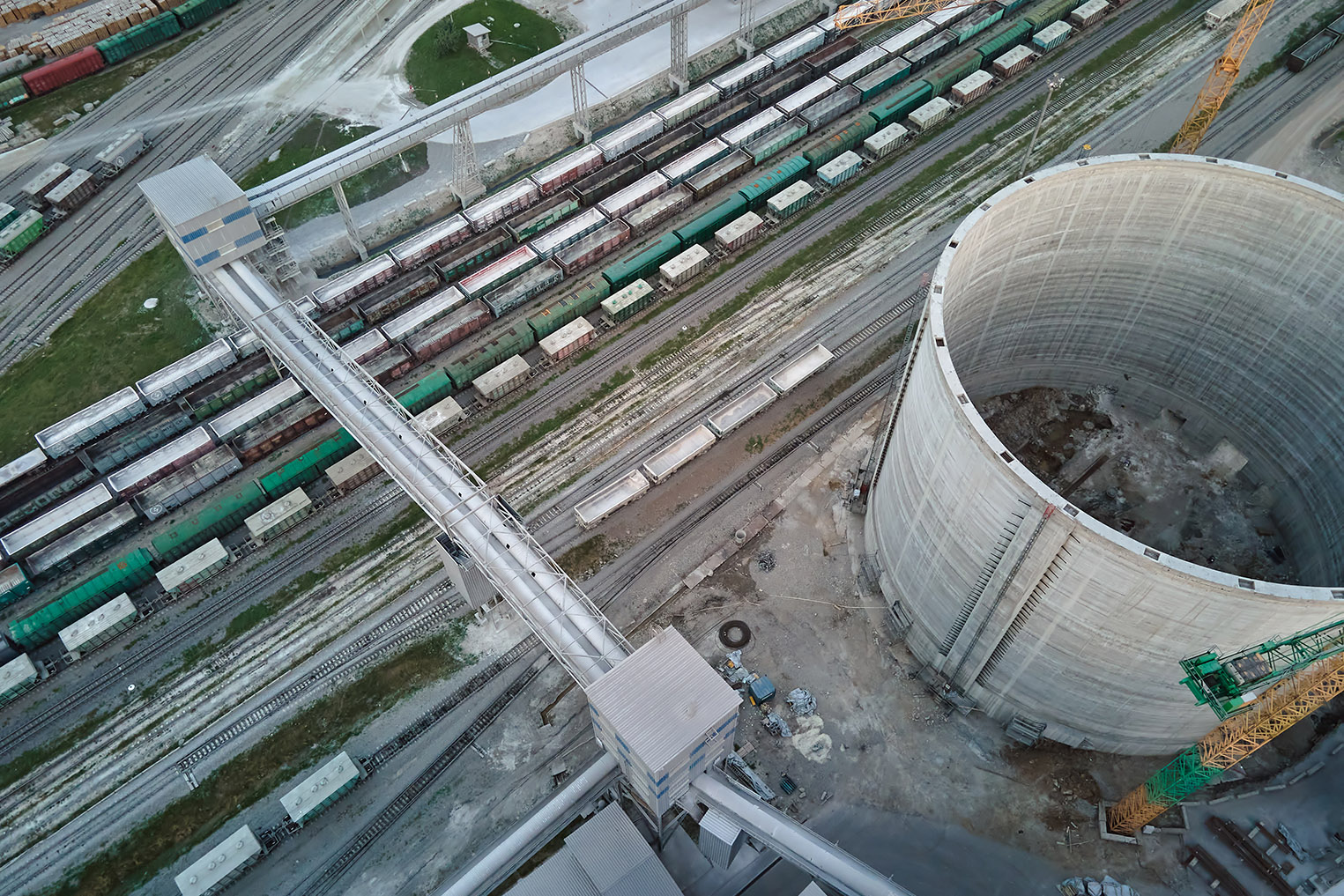 Aerial view of cargo train cars loaded with construction goods at mining factory. Railway transportation of industrial production raw materials.